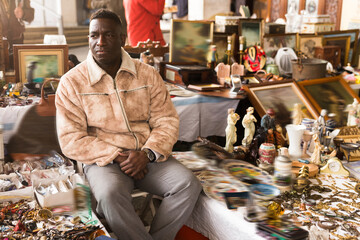 Wall Mural - Ordinary african american guy sells things at a flea market