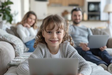 Poster - Young girl seated on sofa using laptop