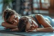 © Sandu - Two females reclining on a mat with eyes shut