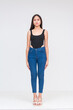© Mdv Edwards - Front view of a pensive young asian woman in a black bodysuit and jeans Isolated on a white background. Whole body photo.
