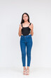 © Mdv Edwards - A young asian woman making thumbs up sign. Wearing a black bodysuit and jeans Isolated on a white background. Whole body photo.