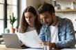 © Sandu - Two individuals examining paper seated at desk