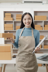 Wall Mural - small business owner Asian woman working at home with boxes and laptop Retail market, business and sales, online marketing, SME ecommerce concepts, vertical image