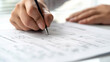 © Apalko - Close-up of a man holding a pen and putting a tick on a piece of paper. The concept of filling out a job application form or voting ballot.
