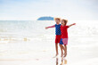 © famveldman - Kids with American flag on beach. 4th of July.