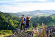 © Halfpoint - Travellers couple hiking on easy trail in nature with backpacks. Young tourist resting, enjoying breathtaking view. Summer vacation oudoors. Rear view.
