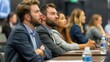 © Emiliia - A group of young professionals sit attentively during a conference, listening intently to a speaker or presentation.