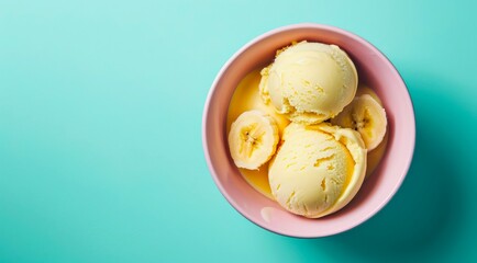 Canvas Print - Bowl of banana ice cream scoops on pastel blue background with copy space, top view.