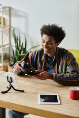 Wall Mural - A young African American man busy with his tablet and phone, multitasking as a content creator.