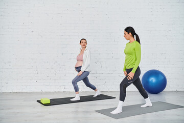 Wall Mural - pregnant woman gracefully flow through yoga poses under the guidance of her prenatal coach during a parents course.