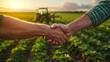 © admin_design - Two farmers shaking hands in green field at sunset, symbolizing trust and cooperation in agriculture.