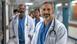 © Minerva Studio - Confident male doctor with team in hospital corridor