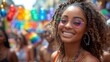 © Old Man Stocker - Smiling Woman at Colorful Pride Parade. Smiling woman with curly hair and colorful glasses at a pride parade, surrounded by rainbow balloons and festive decorations.