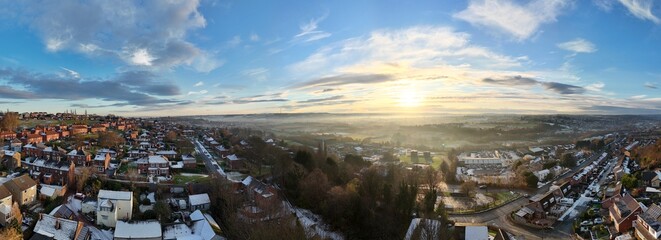 Wall Mural - Urban winter Panorama sunset scene with sweeping vistas misty sunset and snow on the frosty ground. Yorkshire, UK