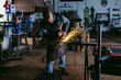 © ADDICTIVE STOCK - Skilled Blacksmith Grinding Metal in Workshop