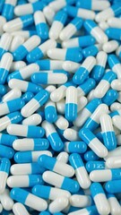 Wall Mural - Heap of gelatin blue white capsules, rotation. Pharmaceutical Industry