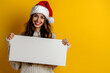 © Marina Shvedak - happy woman holding a white blank sheet of paper, christmas mock up copy space text