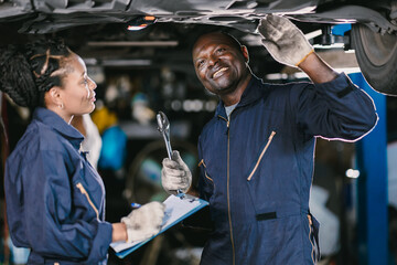 Wall Mural - Mechanic Team Man and Women Staff Working Repair Vehicle in Car Service. Professional Worker Fix Car in Workshop Together.