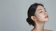 © MD Media - Beautiful woman with perfect skin portrait on gray background, close up of beautiful young asian model in profile looking away from camera