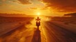 © horizon - A motorcyclist riding on an open road at sunset, with the sun setting in front and desert dunes behind. Web banner with space for text.