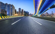 Asphalt highway road and bridge with modern city buildings scenery at night
