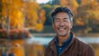 © Антон Сальников - A 50-year-old Asian American man exudes joy and happiness in a natural park near a lake, a genuine smile on his face, a relaxed and confident male who has found joy.