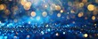 © Антон Сальников - An abstract glittering background containing golden christmas lights and a blue glittery background
