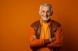 © CogniLens - Portrait of a blissful man in his 70s sporting a stylish varsity jacket in front of soft orange background
