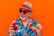 © oneinchpunch - Grandfather portraits on colored backgrounds. Old man with hawaiian shirt celebrating on vacation, and drinking  tropical cocktails.