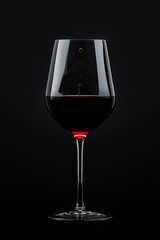 Glass with red wine on a black background