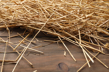 Canvas Print - Pile of dried straw on wooden table