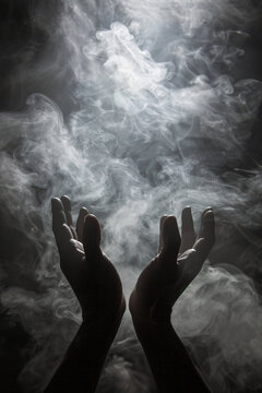 Two hands reaching into a smoke-filled sky against a dark backdrop