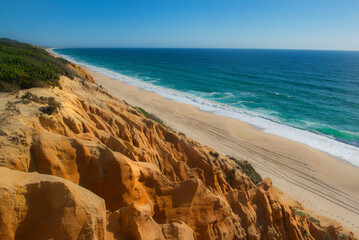 Wall Mural - beautiful beach in the Atlantic Ocean bordered by hard sand cliffs forming a canyon Medides beach in Portugal