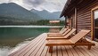 © Marko - wooden sun loungers on the shore of the lake next to a wooden house against the backdrop of mountains and forest
