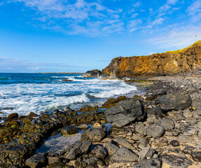 Wall Mural - Waves Washing Over Boulders Below Sea Cliffs on Glass Beach, Port Allen, Kauai, Hawaii, USA