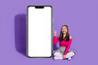 © deagreez - Full length photo of adorable friendly lady dressed pink top showing v-sign typing sms device empty space isolated violet color background