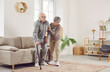 © Studio Romantic - Scene at home as a devoted elderly wife assists senior husband during rehabilitation, offering care and support as he walks with a cane. A testament to love and commitment in the face of challenges.