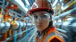 © familymedia - Dynamic portrait of a confident female engineer in safety gear inside a manufacturing plant