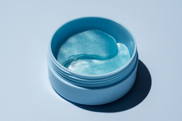 cosmetic hydrogel patches for moisturizing and nourishing the skin around the eyes. blue background.