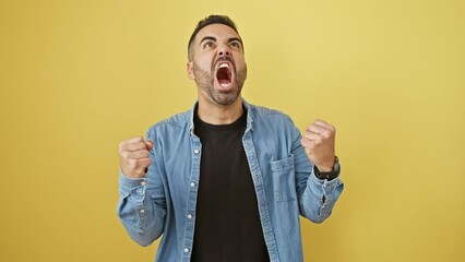 Sticker - Furious young hispanic man in denim shirt, standing with anger, aggressively shouting and screaming. rage and frustration personified on isolated yellow background.