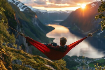 Wall Mural - Sunset view of man in hammock above fjord
