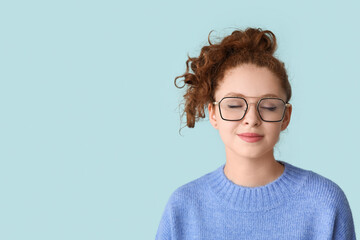 Wall Mural - Portrait of relaxed young woman on blue background