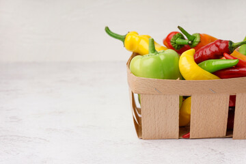 Wall Mural - Basket with different fresh peppers on white background