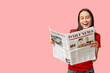 © Pixel-Shot - Beautiful young woman with newspaper on pink background
