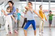 © JackF - During dance workshop, girl with team of young like-minded children learn to dance modern dances. Woman teacher corrects movements of hands and body, instructs students to perform dance movements