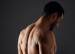 © peopleimages.com - Sexy, muscle and back of man for exercise with workout, gym aesthetic and results for fitness goals in studio. Topless guy, bodybuilder and strong body with shoulder training by black background