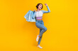 © deagreez - Full body photo of delighted cheerful lady hold mall shop bags raise fist success isolated on yellow color background