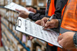 © Andres Mejia - Warehouse worker checking inventory using clipboard in a retail warehouse