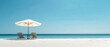 © STOCKYE STUDIO - white sand beach in a sunny day, umbrella with wooden chairs
