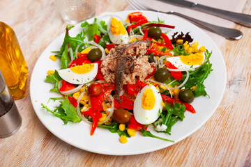 Wall Mural - Traditional Catalonia food, salad xato with codfish, eggs and olives on a ceramic plate